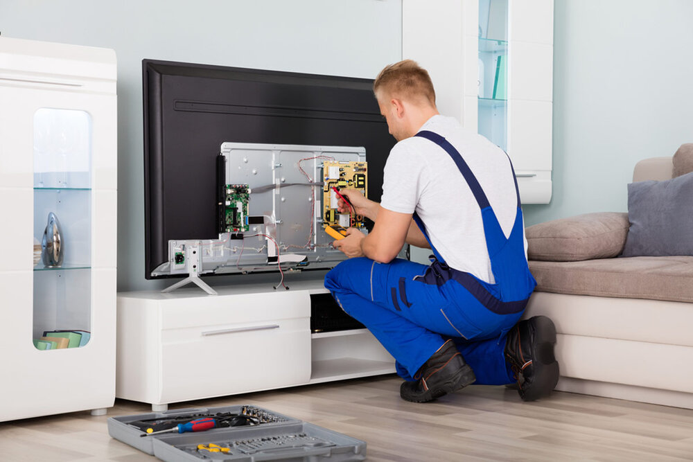 Technician repairing a television at the VE workshop